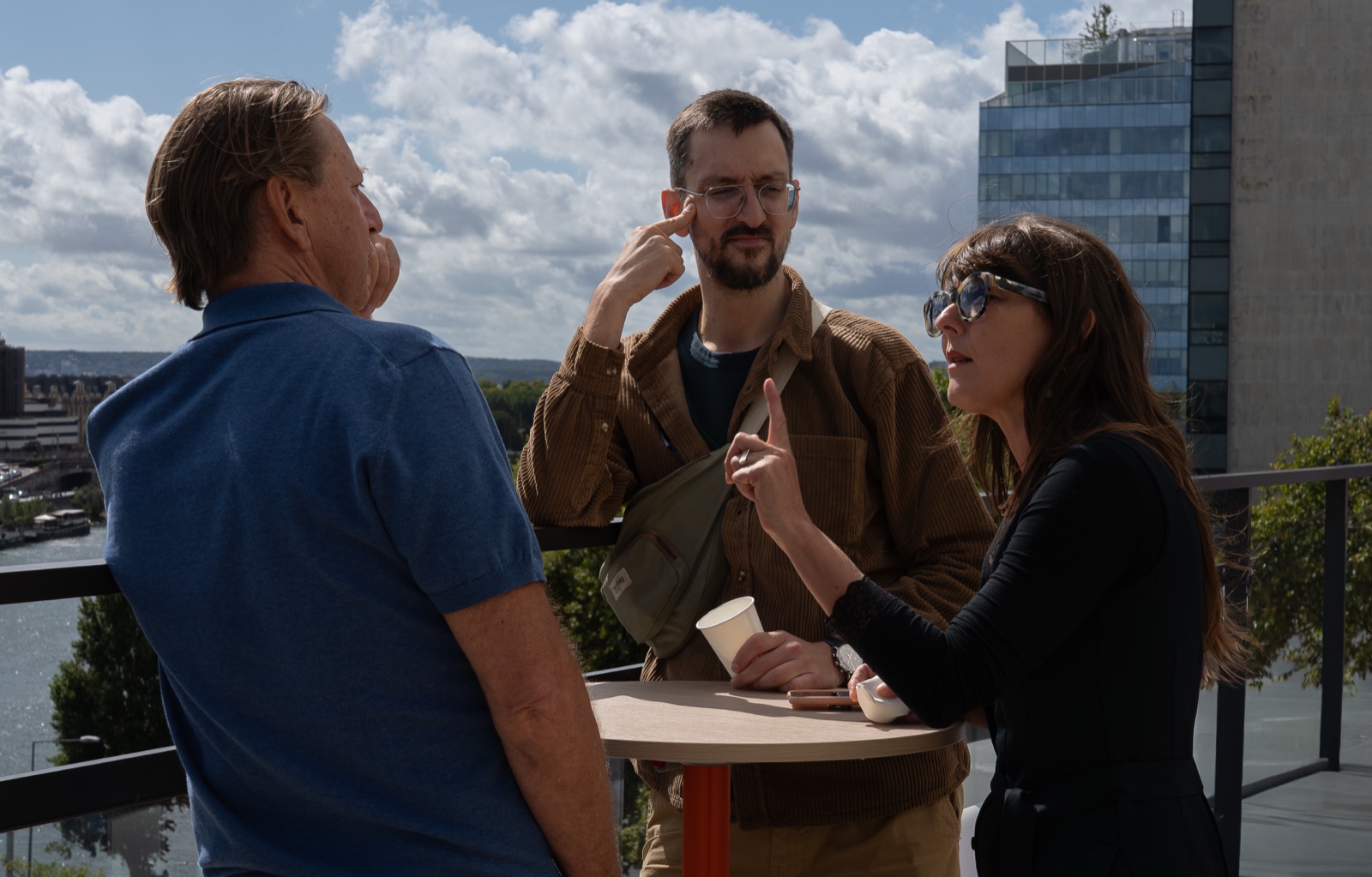 Trois participants en pleine discussion sur le rooftop